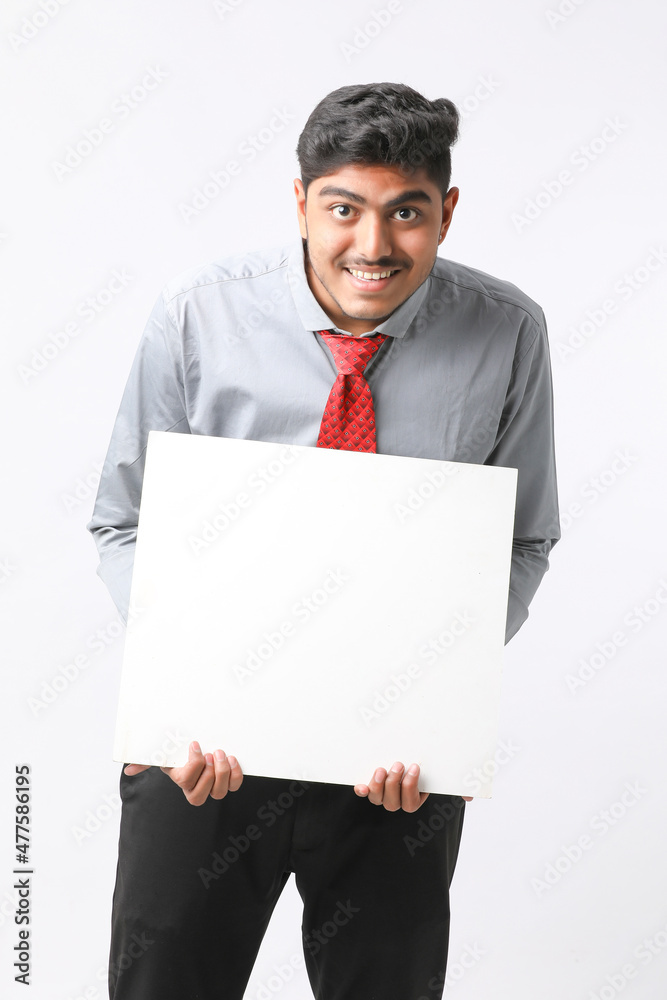 Young Indian business executive showing blank sign board over white background. Young Indian business executive showing blank sign board over white background.