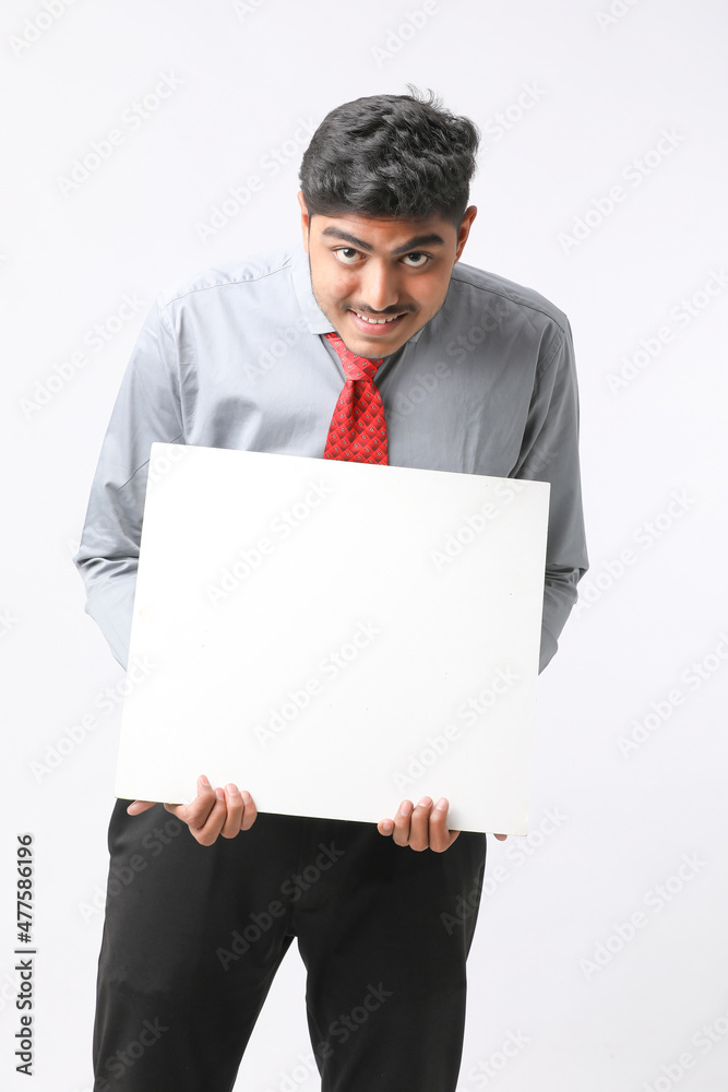 Young Indian business executive showing blank sign board over white background. Young Indian business executive showing blank sign board over white background.