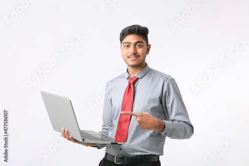 Young indian man using laptop on white background.