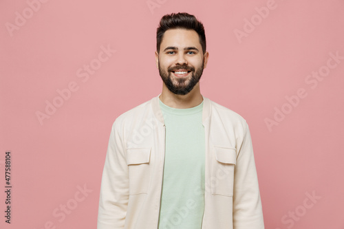 Young smiling happy cheerful friendly fun european caucasian man 20s wearing trendy jacket shirt look camera isolated on plain pastel light pink background studio portrait. People lifestyle concept.