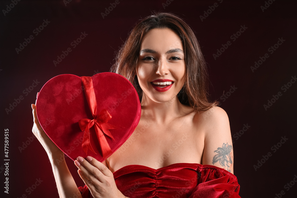Sexy young woman with gift on black background. Valentine's Day celebration Sexy young woman with gift on black background. Valentine's Day celebration