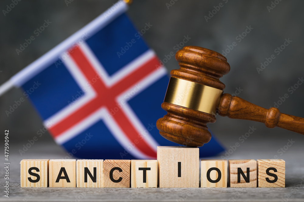 Judge gavel, wooden cubes with text on the background of the Icelandic flag, concept on the theme of sanctions in Iceland