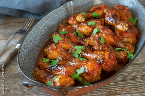 Honey glazed chicken drumsticks with barbecue sauce in a roasting pan
