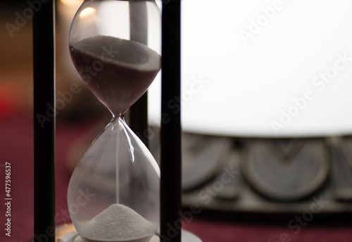 hourglass with sand on the table near the glass ball for fortune telling