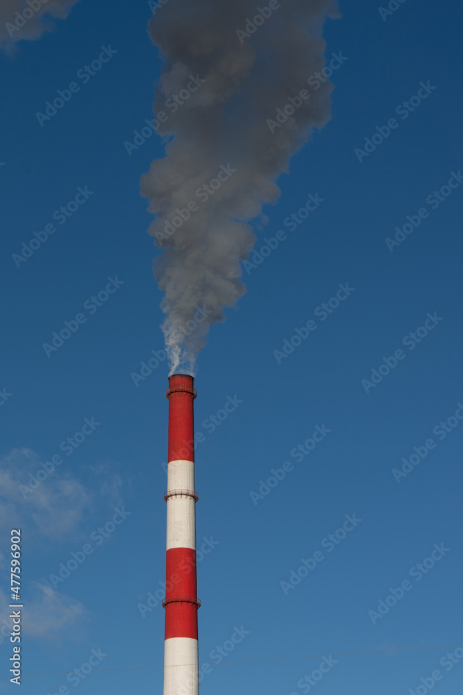 smoke comes from the chimney against the background of a blue clear sky smoke comes from the chimney against the background of a blue clear sky