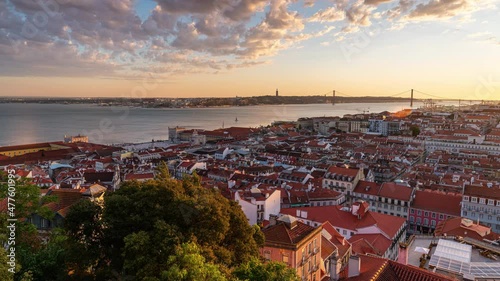 Time Lapse of a colourfull sunset over the old town of Lisbon in Portugal with the 25th of April Bridge in the background photo