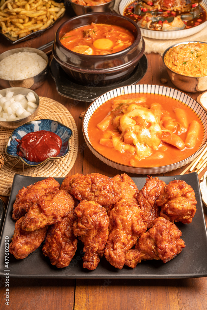 Traditional Korean food, Korean Fried chicken with spicy sauce with rice, seaweed,fresh raw crabs marinated,spicy Rice Cake and Kimchi pickle on wooden table. Traditional Korean food, Korean Fried chicken with spicy sauce with rice, seaweed,fresh raw crabs marinated,spicy Rice Cake and Kimchi pickle on wooden table.