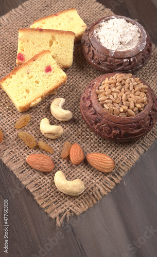 Slices of home made wholemeal bread on a white background with wheat and flour.