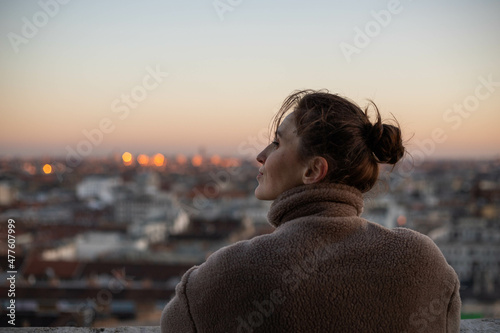young woman on the tower looks at the city
