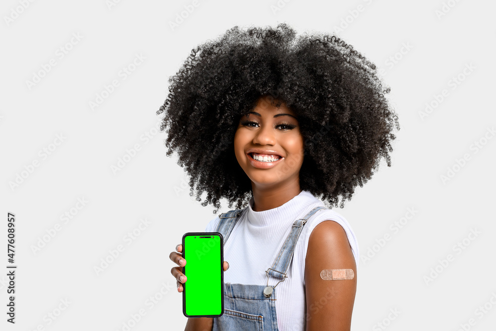 black girl without face shield holds the cell phone close to her arm with the vaccine sticker, fully immunized, chroma key on the cell phone screen, black girl without face shield holds the cell phone close to her arm with the vaccine sticker, fully immunized, chroma key on the cell phone screen,