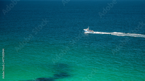 A single motorboat, cutting through the clear seas, just off the coast of St. Ives, Cornwall, England on a sunny summer's day. Room for copy