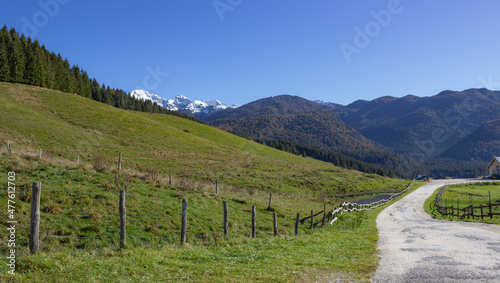 Mountain landscape. A white road recreated by the wooden fence with the background of the mountains. Val Menera, Italy. photo