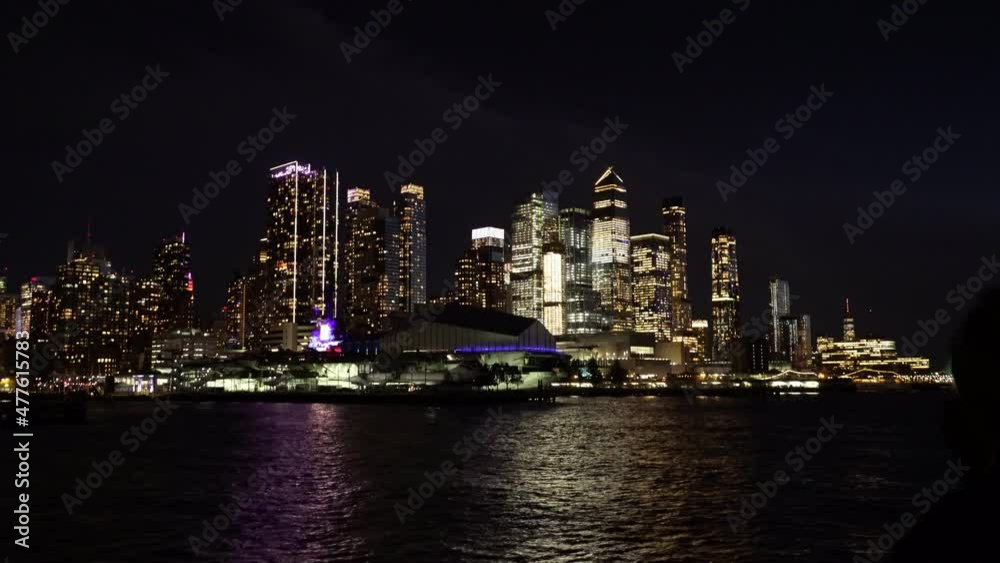 skyscrapers of Lower Manhattan in New York city, illuminated at night. Tourists take photos of it skyscrapers of Lower Manhattan in New York city, illuminated at night. Tourists take photos of it