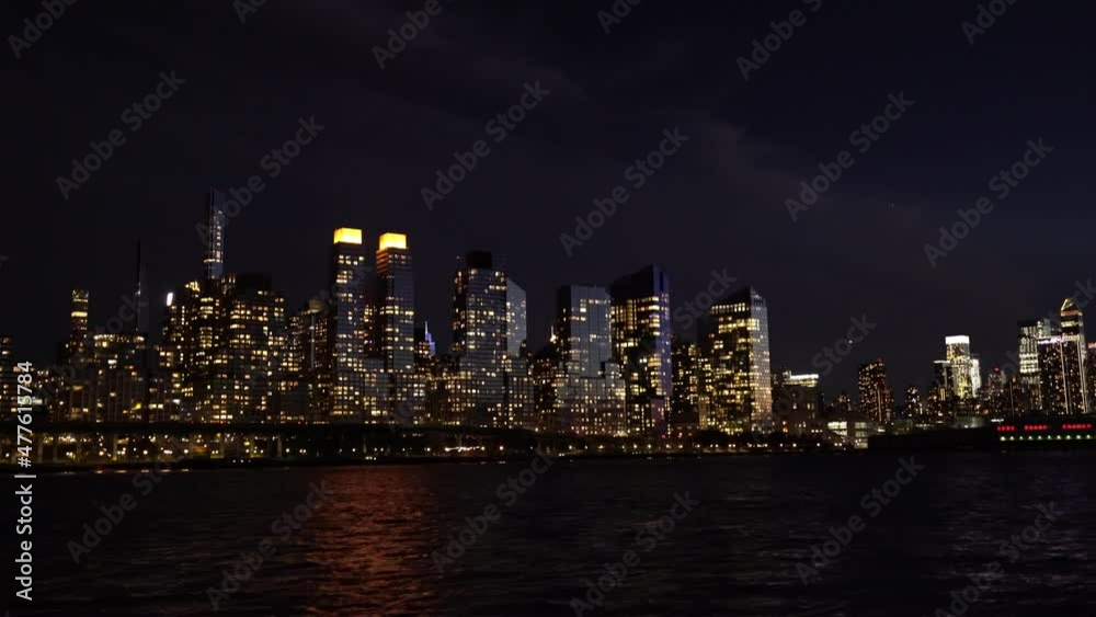 New York Nightscape by the East river. Lit Buildings reflecting on water surface New York Nightscape by the East river. Lit Buildings reflecting on water surface