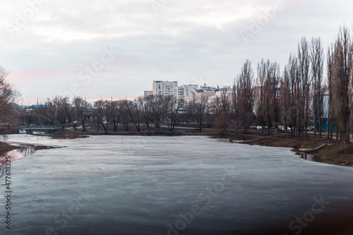 Winter river landscape at sunset,  water icovered with ice