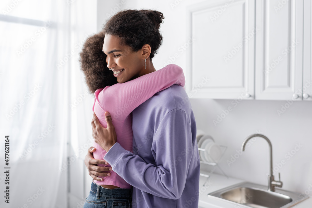 Young african american man hugging girlfriend at home. Young african american man hugging girlfriend at home.