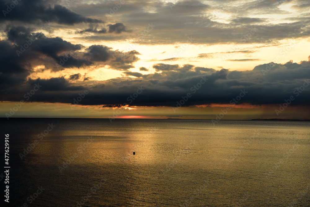 Panorama shots of gorgeous sunset over the Pacific Ocean with puffy rain clouds in the background. 