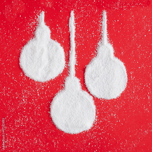 Christmas baubles made of powder on a christmas red colour. Flat lay holiday composition.