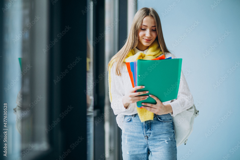 Girl student standing with colorful folders Girl student standing with colorful folders