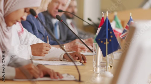 PAN shot of male and female political leaders of different countries signing contracts at public conference