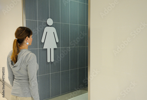 Woman enters public restroom.
