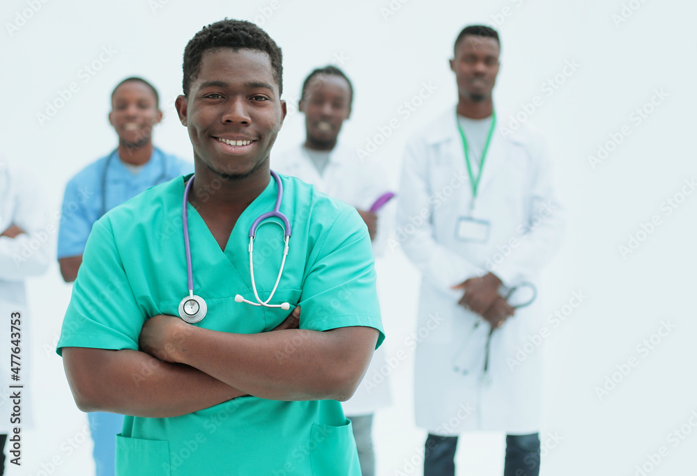 smiling surgeon standing in front of his colleagues smiling surgeon standing in front of his colleagues