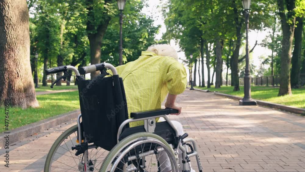 Injured woman trying to stand up from wheelchair, rehabilitation period, health Injured woman trying to stand up from wheelchair, rehabilitation period, health