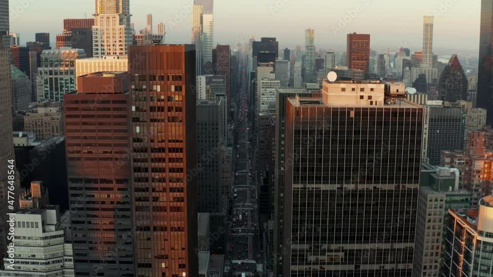 Long wide straight avenue surrounded by high rise office or apartment buildings. Aerial view of city centre at dusk. Manhattan, New York City, USA Long wide straight avenue surrounded by high rise office or apartment buildings. Aerial view of city centre at dusk. Manhattan, New York City, USA