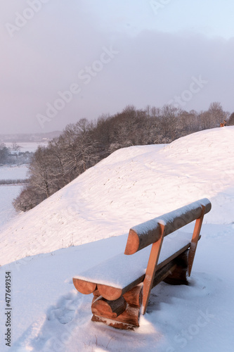 a bench at the top of the mound overlooking the river