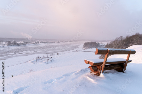 a bench at the top of the mound overlooking the river