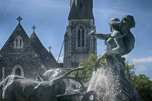 Copenhagen, Denmark - St. Alban's English Church in Gothic Revival style and goddess Gefion fountain from 1908,the largest monument in Copenhagen photo