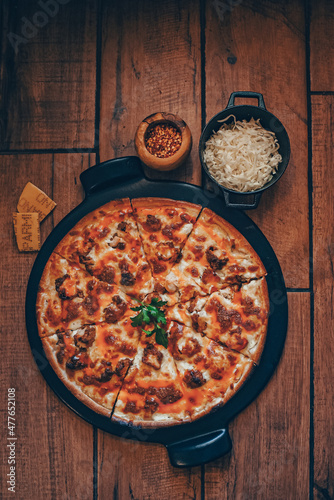 Buffalo chicken pizza pie on pizza stone with wooden background