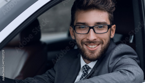 businessman in suit driving his luxurious car.