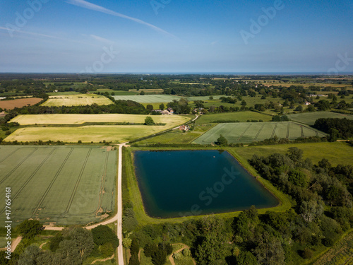 A patchwork of farm field in the Suffolk countryside with a large reservoir in the foreground