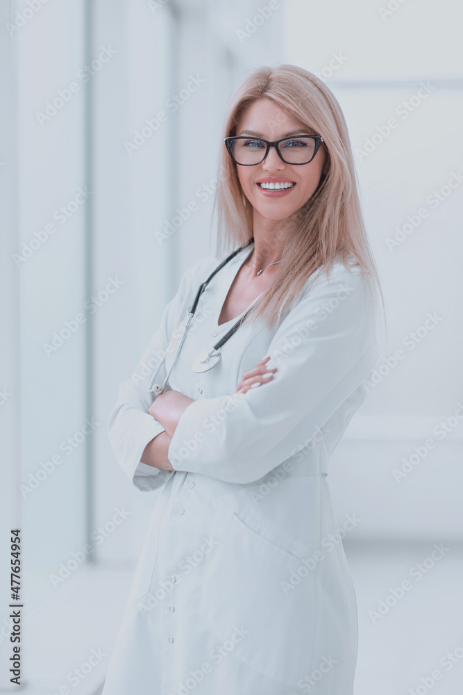 smiling woman doctor standing near the hospital window smiling woman doctor standing near the hospital window