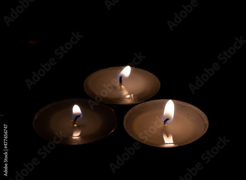 Lit candles. Dark background. Commemorative candles.