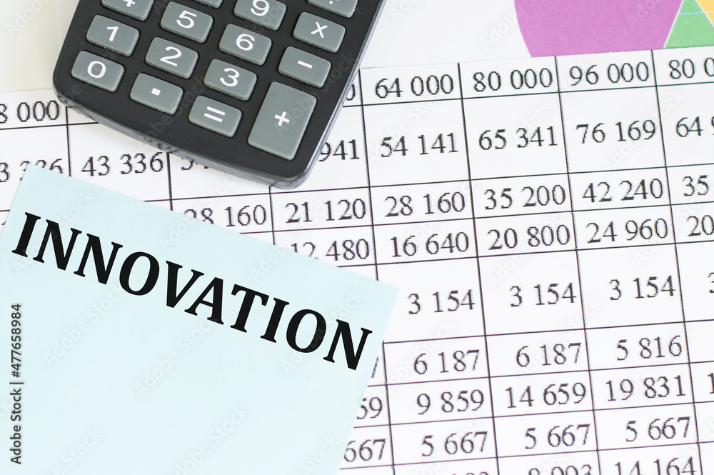 Innovation text on paper for notes on background reports next to the calculator on the table, a business concept Innovation text on paper for notes on background reports next to the calculator on the table, a business concept