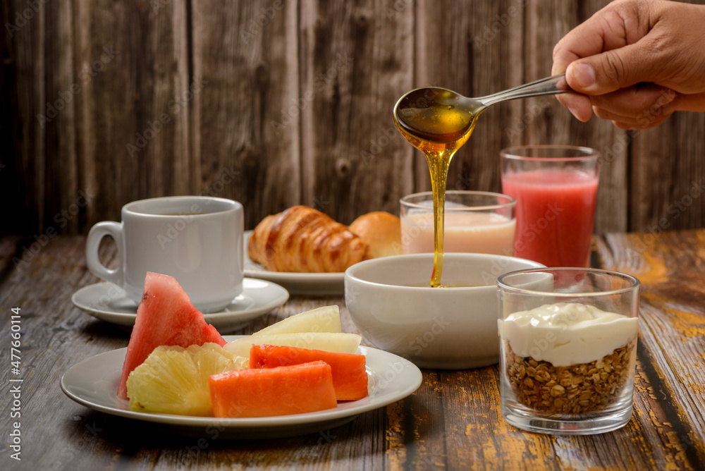 Breakfast table with emphasis on tropical fruits and bee honey.