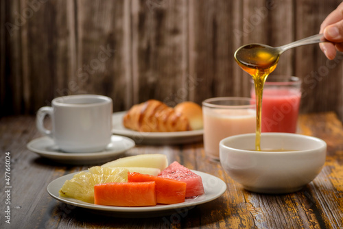 Breakfast table with emphasis on tropical fruits and bee honey.