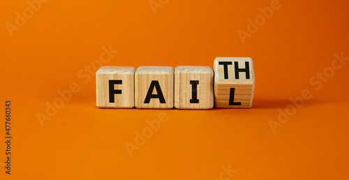 Faith instead fail symbol. Turned a wooden cube and changed the word fail to faith. Beautiful orange table, orange background. Business and faith instead fail concept. Copy space.