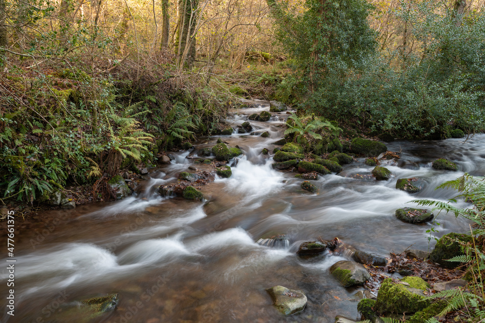 Long exposure of a waterfall on the river Horner in Horner woods in Somerset Long exposure of a waterfall on the river Horner in Horner woods in Somerset