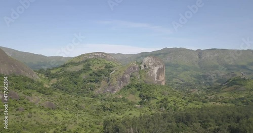 Aerial drone footage of a tropical landscape, with forest and mountains Kumbira forest reserve, small village and huge geologic rock elements, on Conda, Sumbe, Angola photo