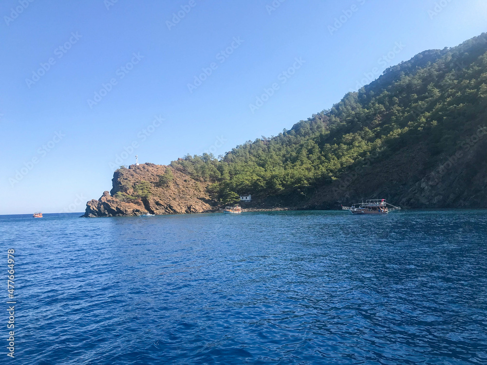 Beautiful blue sea and small ships against the backdrop of high mountains in a warm tourist tropical country. Landscape Beautiful blue sea and small ships against the backdrop of high mountains in a warm tourist tropical country. Landscape
