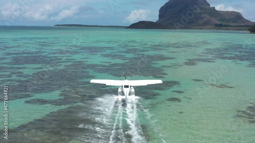 Aerial view. White hydroplane takeoff in a calm lagoon photo