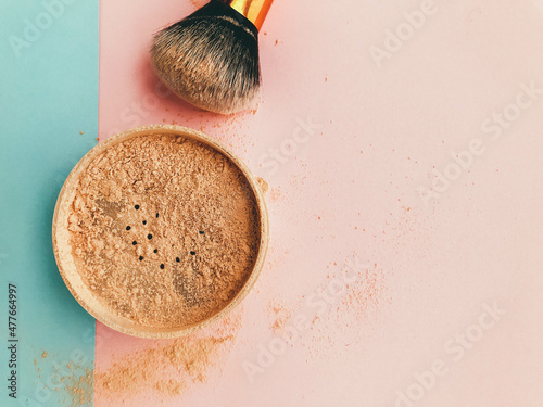 loose matte powder on a glamorous pink and blue background. a tool for a makeup artist. make-up for the face, creation of masks and make-up. mineral powder photo