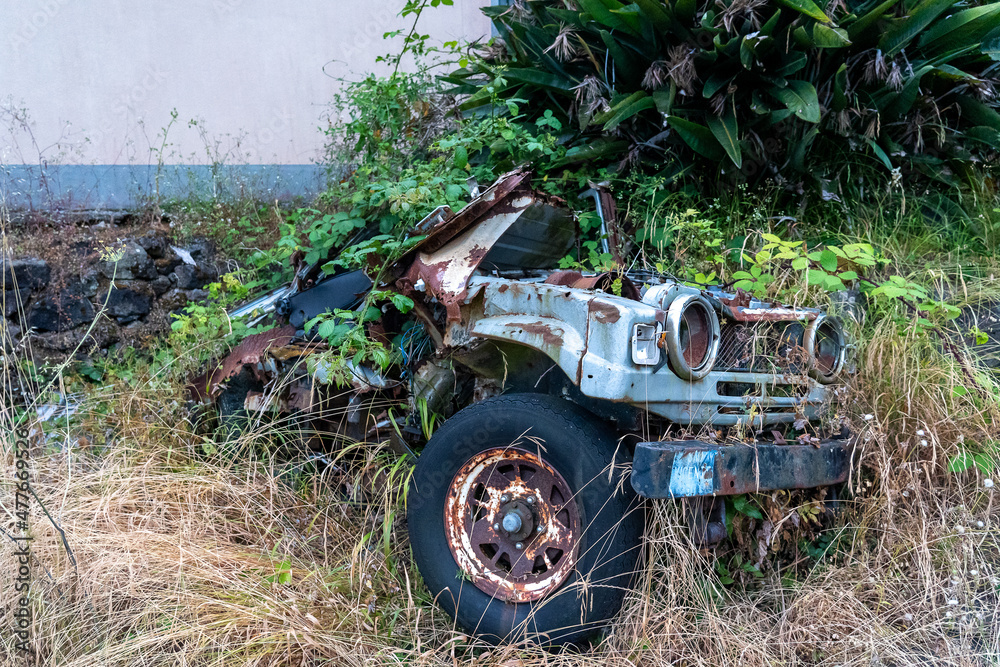 Fototapeta premium Abandoned car left near the wall