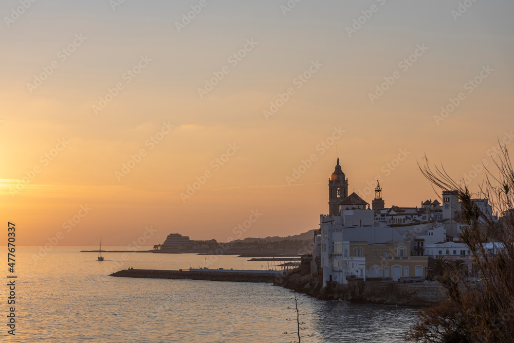 Sunset over the sea in Sitges, an old town with a beach, bars and restaurants on the Mediterranean Sea, Catalonia, Spain near Barcelona.
