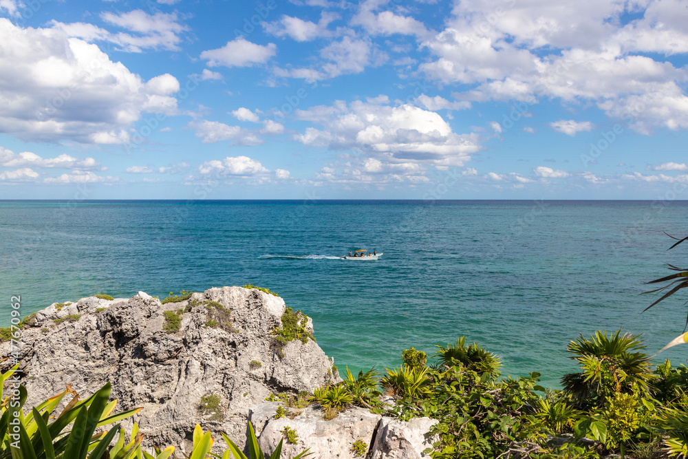 Paisaje paradisiaco de lancha en aguas de playa Paraíso en ruinas de Tulum, Quintana Roo, Mexico.