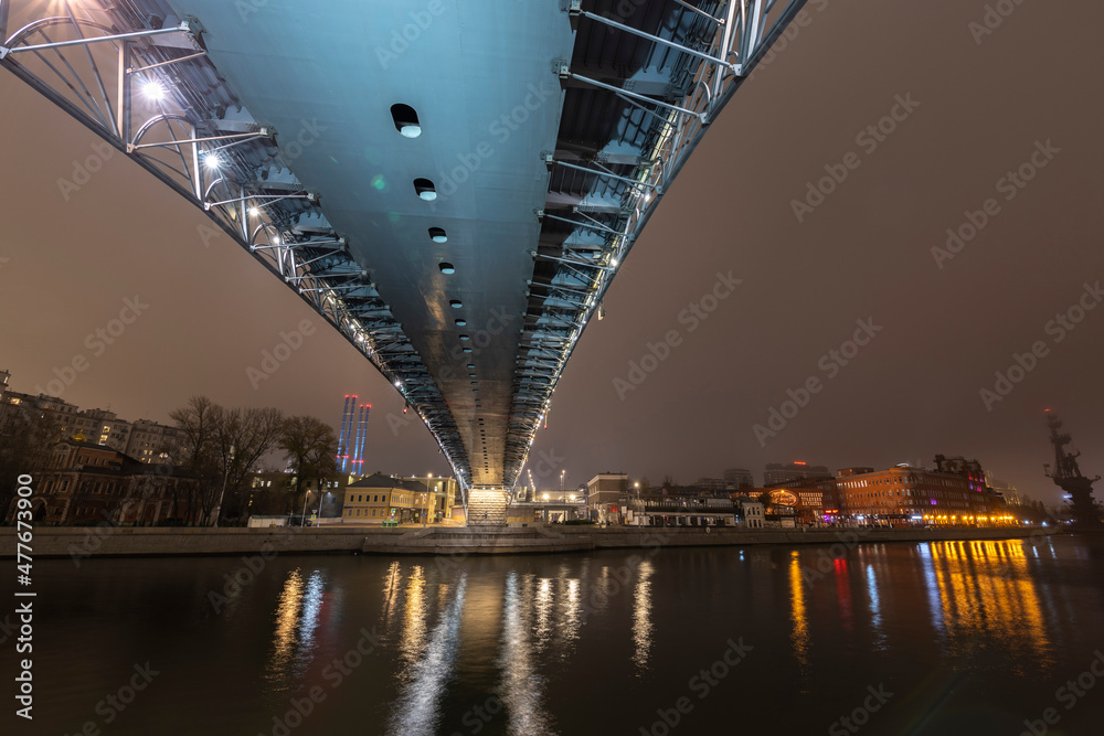 The bridge is illuminated by cold light. Night in the city. Illumination of the metal structure of the bridge. The bridge is illuminated by cold light. Night in the city. Illumination of the metal structure of the bridge.