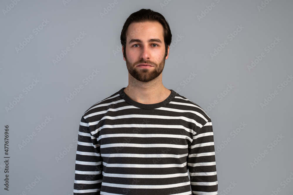 Obraz premium Portrait of attentive self confident bearded man looking at camera with serious expression